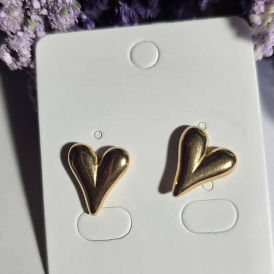 Aretes pequeños dorados de acero inoxidable en forma de corazón con diseño moderno y acabado brillante.

