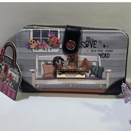 Billetera de mujer Nikky by Nicole Lee con estampado de perros en un banco y frase “Love is a four-legged word”, con detalles florales y broche metálico decorativo.

