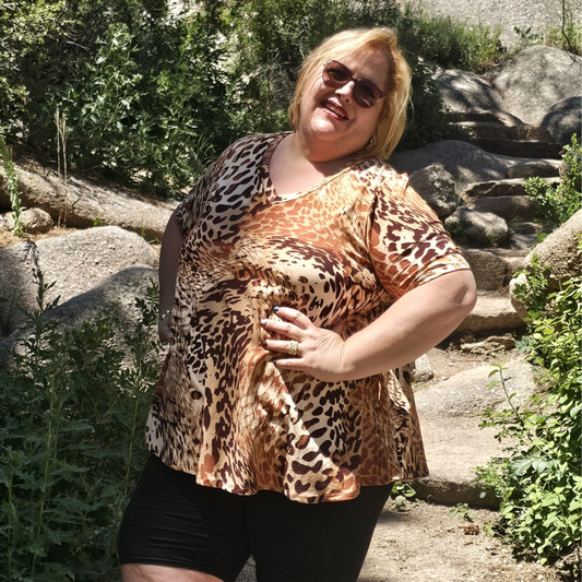Blusa de dama con estampado tipo animal print en tonos marrón, beige y negro, de corte holgado y cuello en V. 