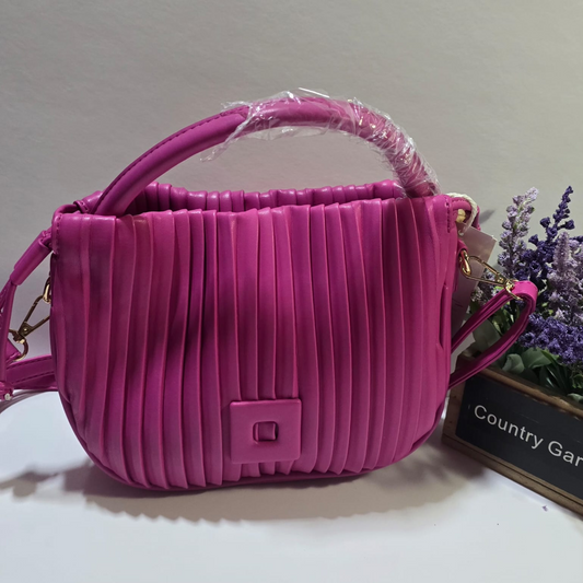 Cartera fucsia con diseño plisado, asa superior acolchada y correa ajustable, estilo moderno y elegante.

